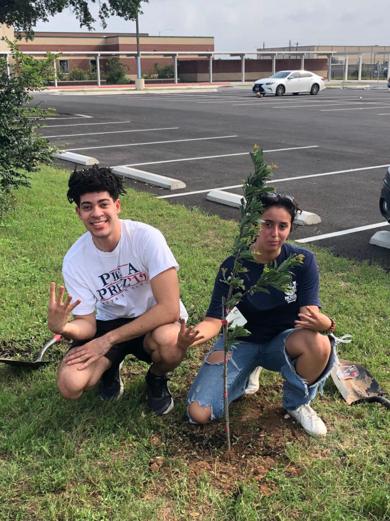 Anish and a volunteer planting a new tree at McNeil High School