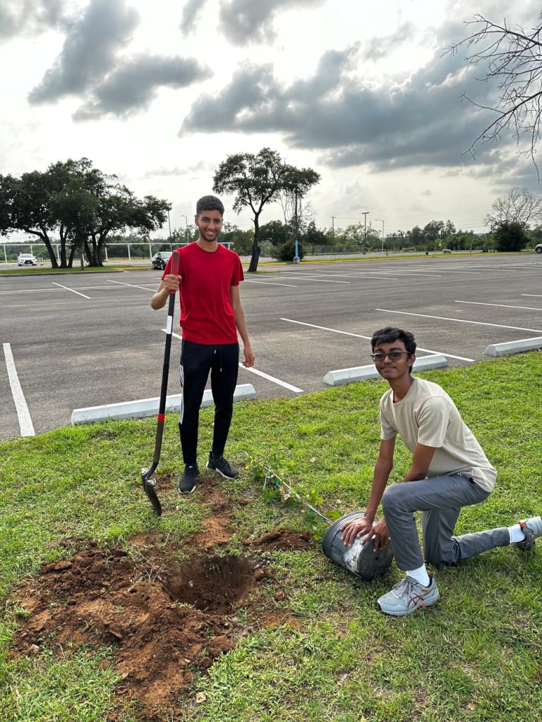 Anish and a fellow student prepare to plant an oak tree next to the Mcneil high school parking lot