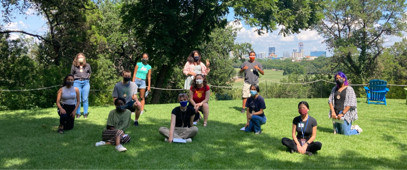 Photo: Youth Forest Council members stand outside in nature. The Austin skyline is behind them.