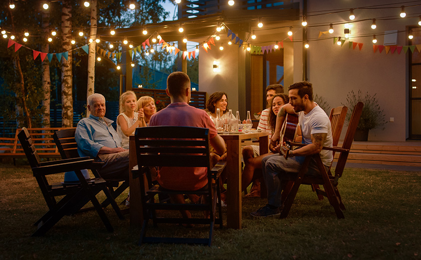 Friends surrounding table playing guitar