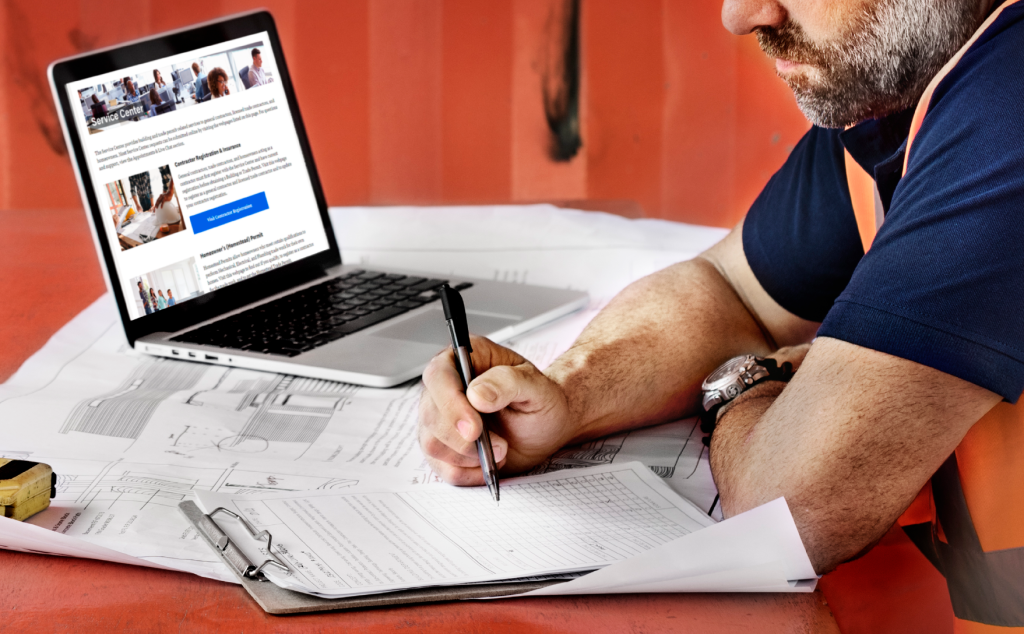 man sitting in front of laptop with red background