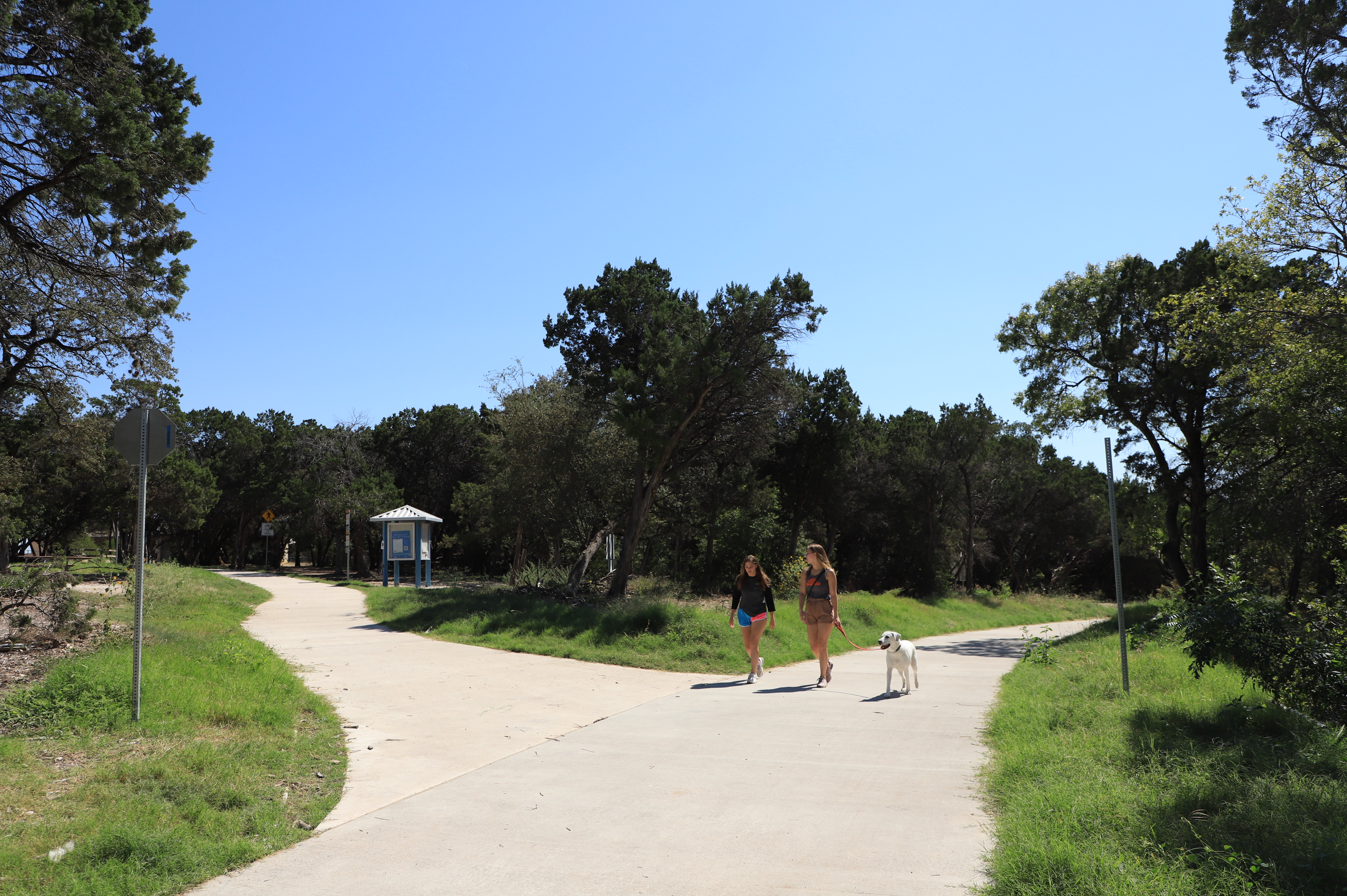 two women walk with a dog on the new trail