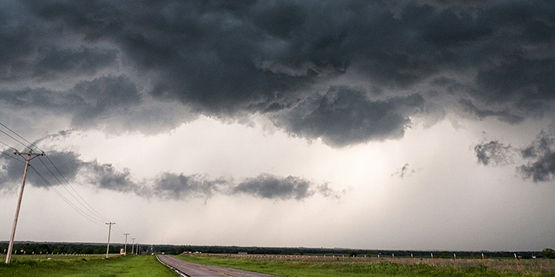 A photo of stormclouds over a country road.