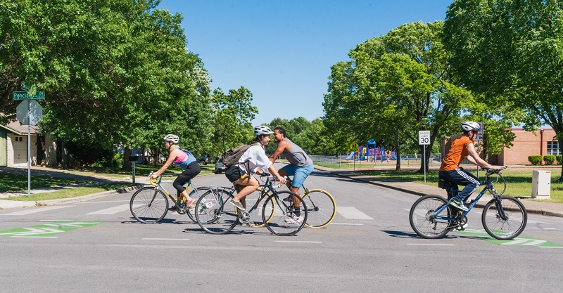 People bike across a road