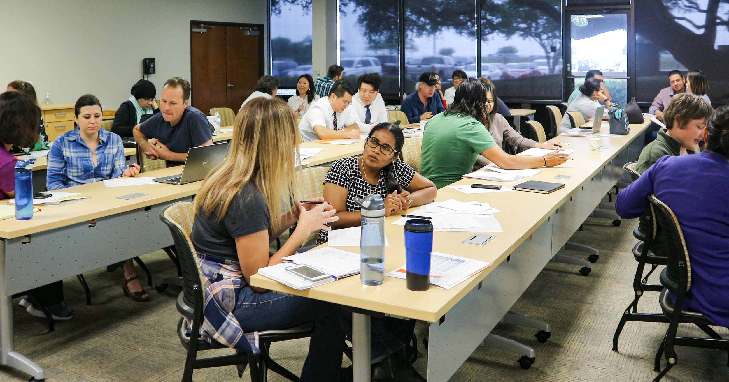 People sitting in a class room talking.