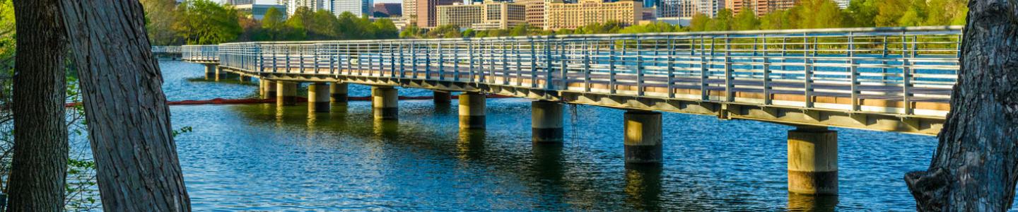 Photo of bridge over water with Austin skyline in background