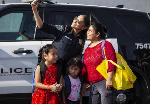 Officer taking selfie with mother and daughter