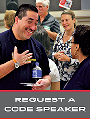 photo of a code inspector talking to a woman with his hand over his heart with the words "Request a code speaker"