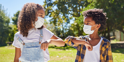 Two kids wearing masks at summer camp