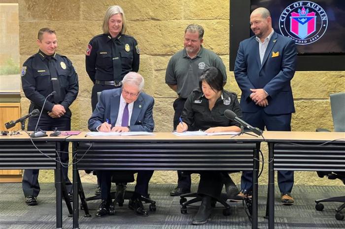 Austin Interim City Manager Jesús Garza and Austin EMS Association President Selena Xie signing contract.