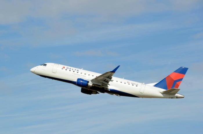 An image of a Delta Air Lines airplane in the sky flying.