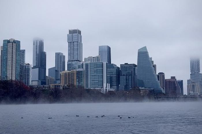 The downtown Austin skyline viewed from Lady Bird Lake with fog coming off the water