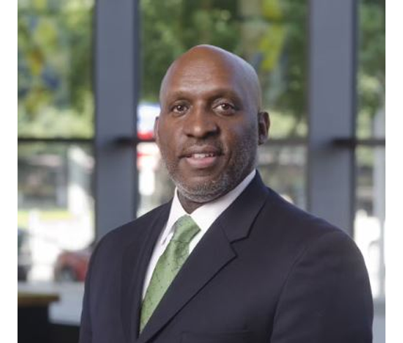 Picture of new Austin City Manager TC Broadnax wearing a dark gray suit with a white shirt and light green tie.