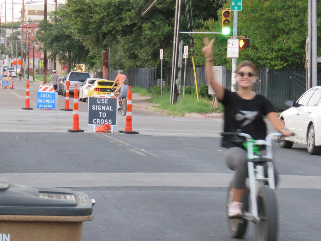 Bicycle rider showing peace sign while riding bike